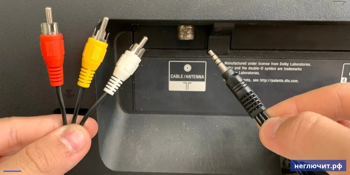 Руки подключают кабель RCA с цветными тюльпанами к задней панели телевизора